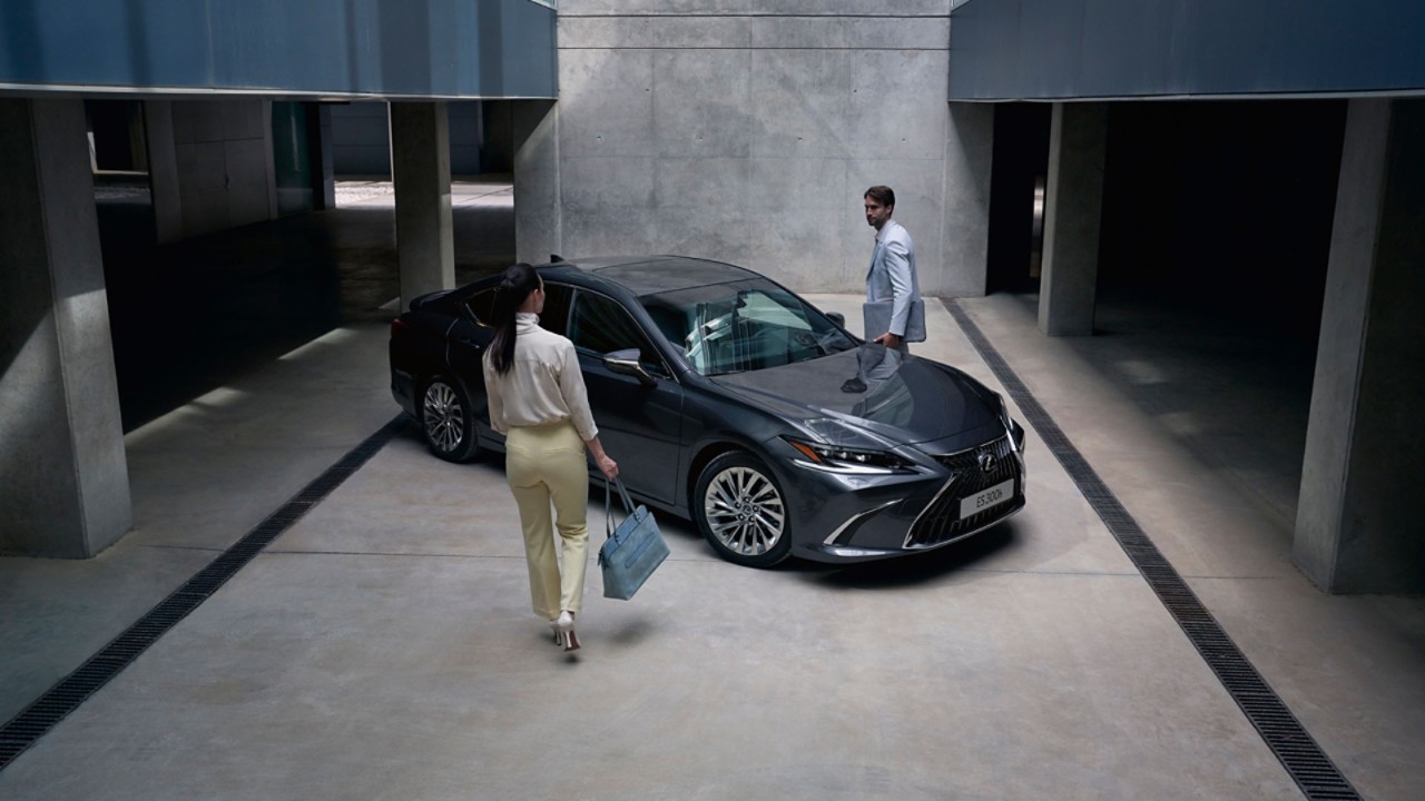 Two people stood by a parked Lexus ES